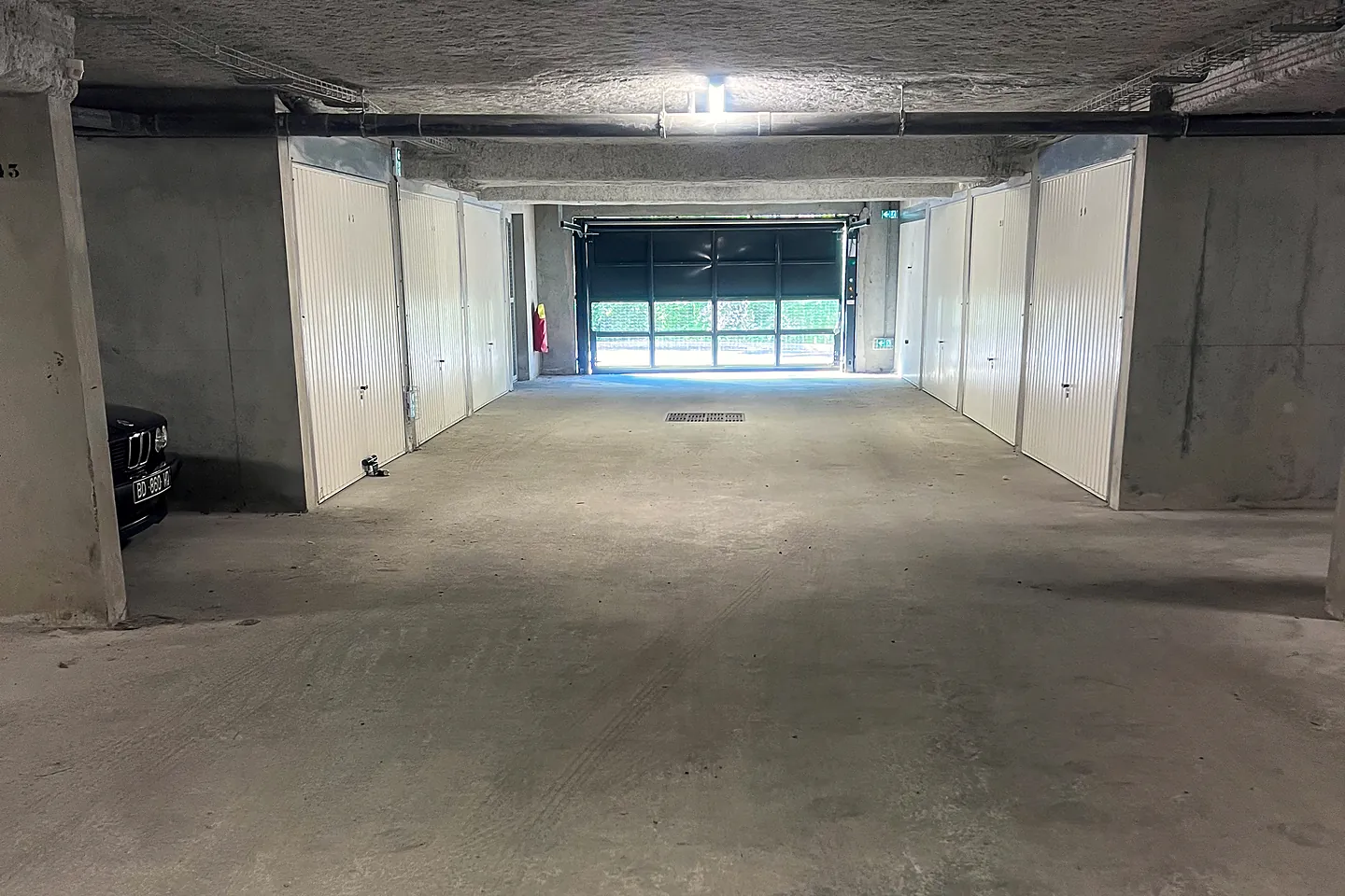 Sous-sol de résidence propre et dégagé, portes de box alignées