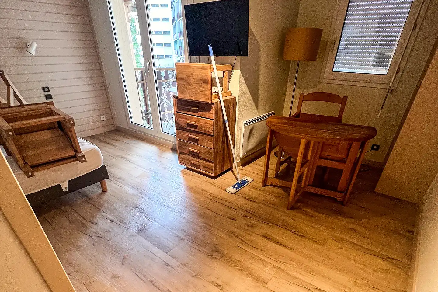 Studio en cours d’intervention, chaises relevées et balai sur le parquet